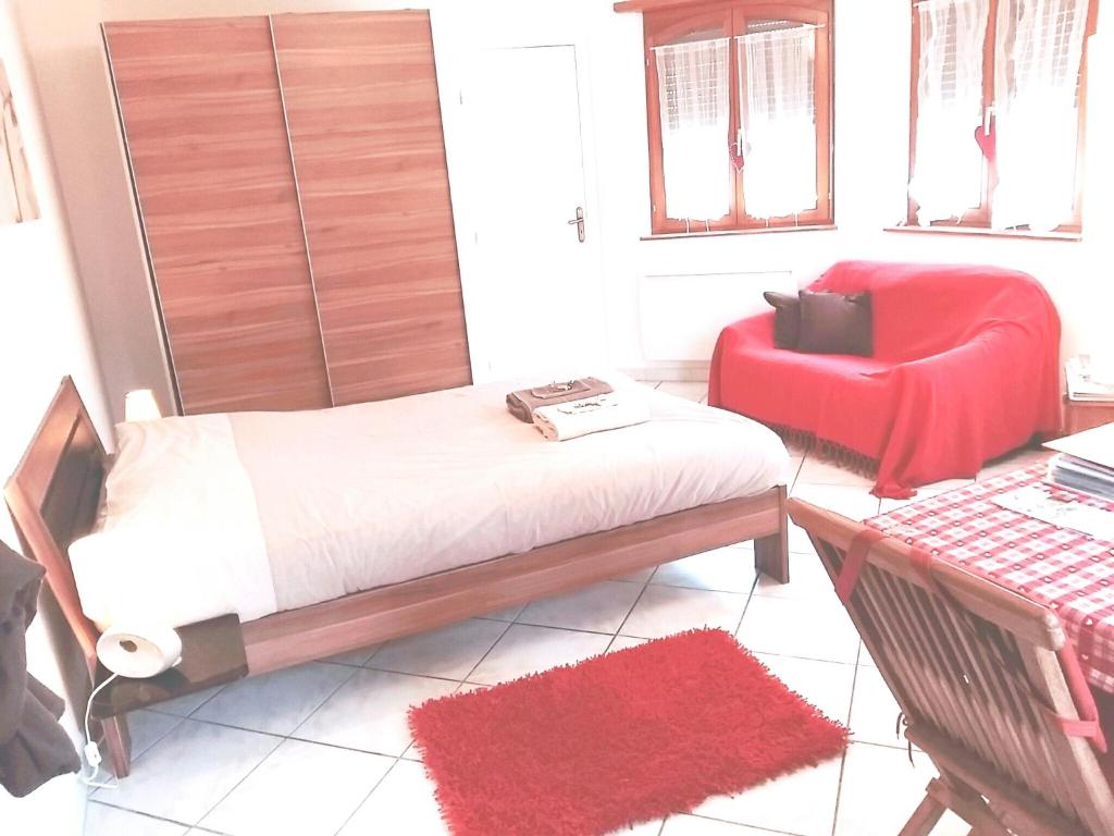 1 dormitorio con 1 cama y 1 silla roja en B&B bio en Dieffenthal