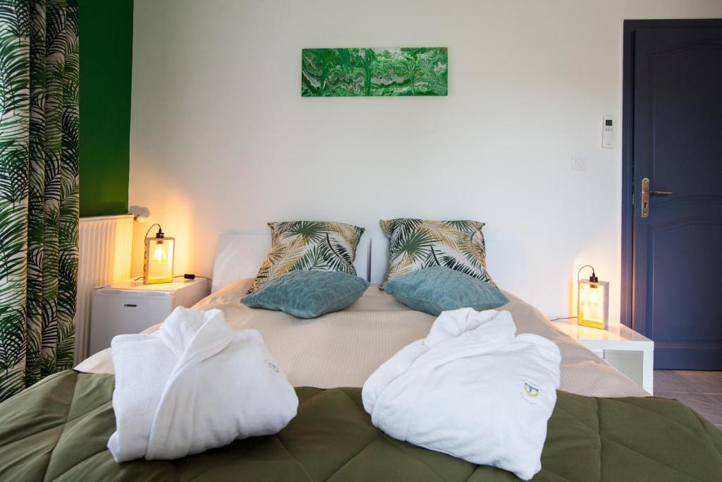 - un lit avec 2 serviettes blanches dans l'établissement Les villas du triangle - chambres d'hôtes, à Nîmes