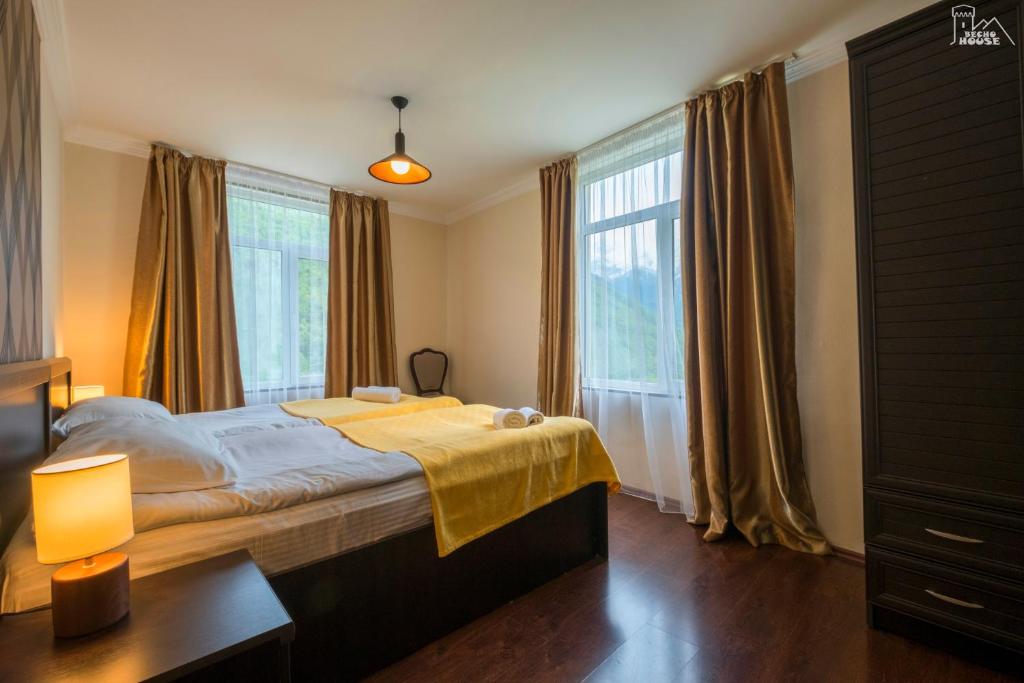 una camera da letto con un letto con una coperta gialla sopra di Becho House a Becho