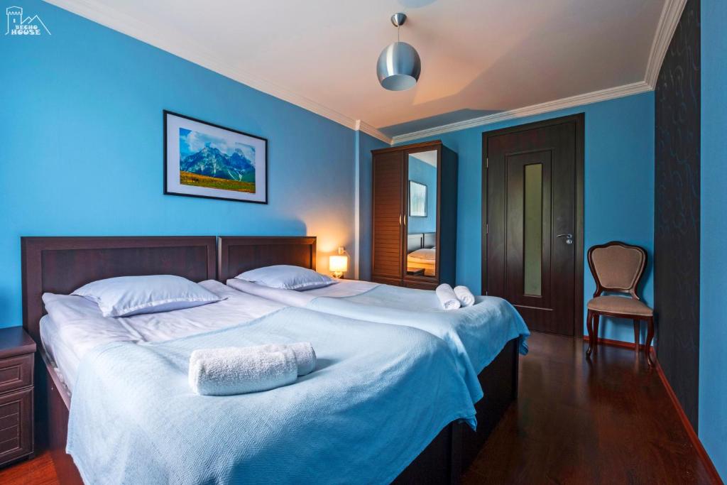 a bedroom with a large bed with blue walls at Becho House in Becho
