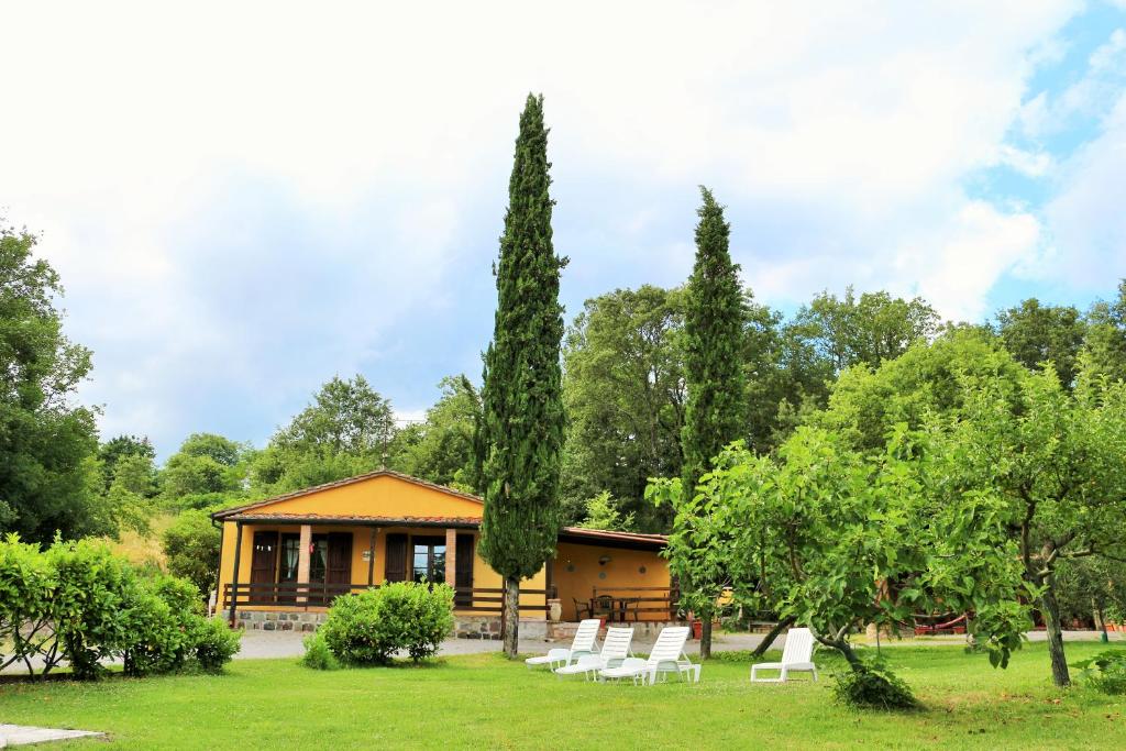 une maison avec un groupe de chaises et d'arbres blancs dans l'établissement Casa San Francesco, à Radicofani