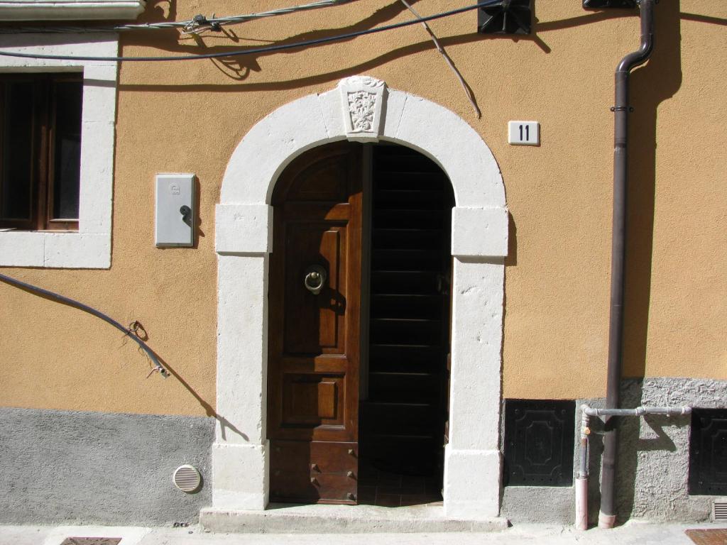een toegang tot een gebouw met een houten deur bij GranSasso Dream House in Carapelle Calvisio