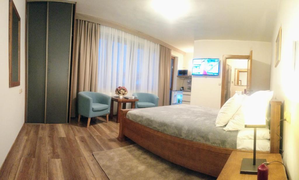 ザコパネにあるPokoje w CENTRUM "CICHA"のベッド、テーブル、椅子が備わるホテルルームです。