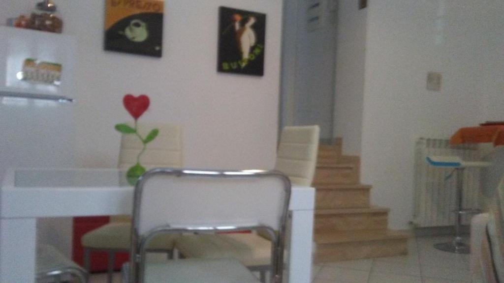 een kamer met een stoel en wat foto's aan de muur bij Casa Valentina in San Benedetto del Tronto