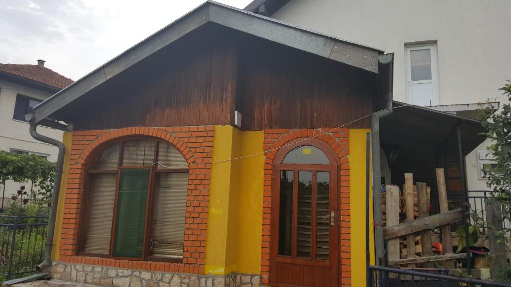 una pequeña casa de color amarillo y naranja en Apartman "Athos" prizemlje, en Višegrad