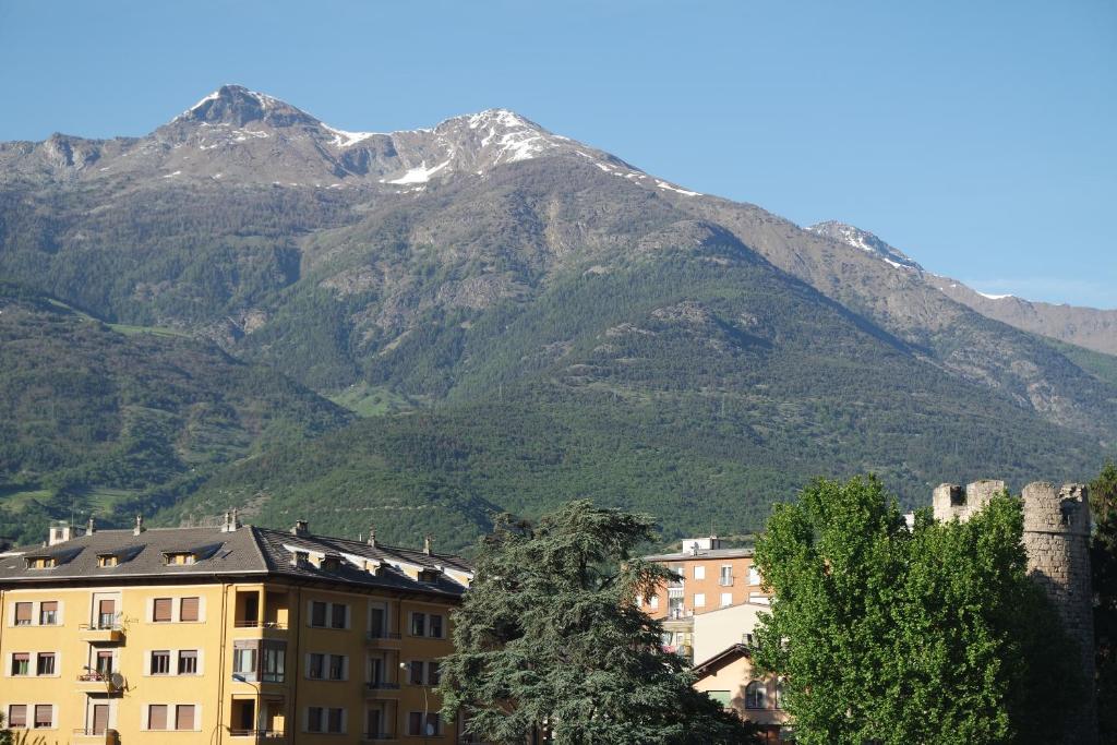 una montaña en la distancia con un edificio y árboles en Appartamento a 100 metri da Piazza della Repubblica Aria condizionata CIR 0053, en Aosta