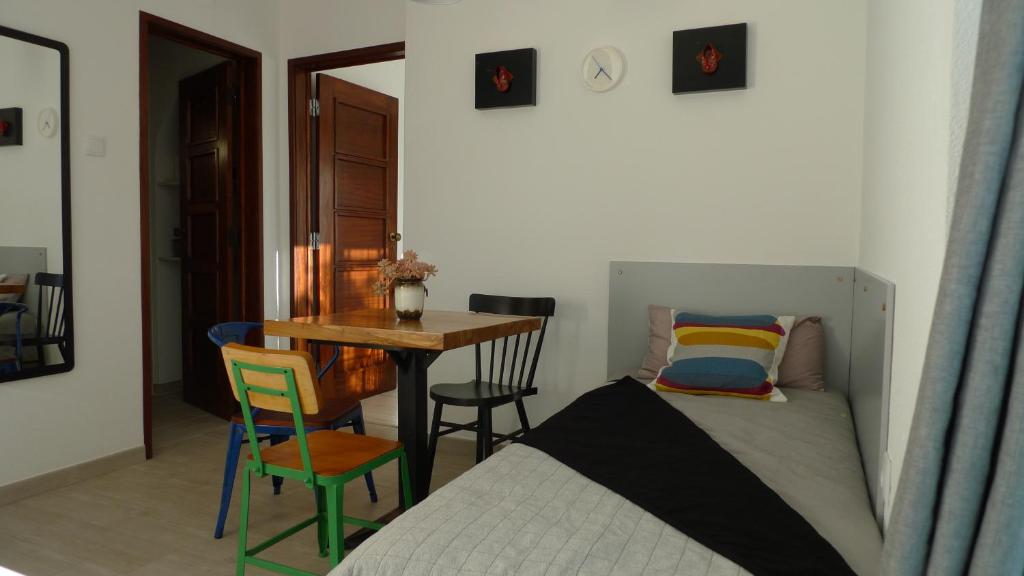 a bedroom with a bed and a table and chairs at Lei Home in Cascais