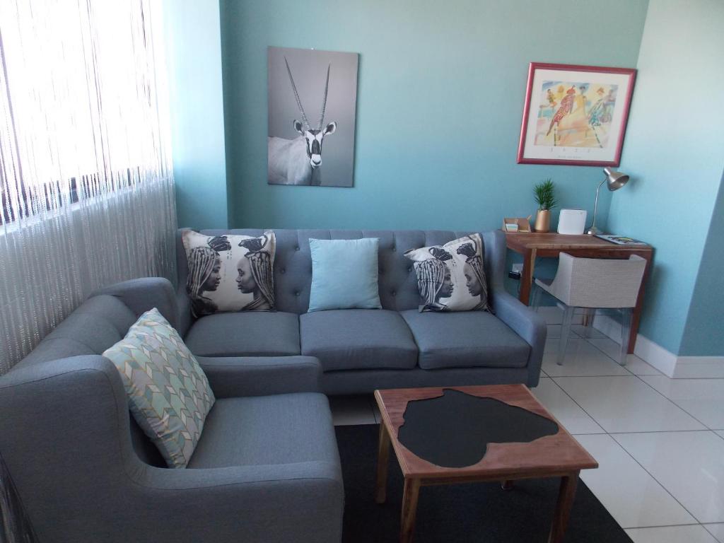 a blue living room with a couch and a table at Unit 46 @ 77 on Independence in Windhoek