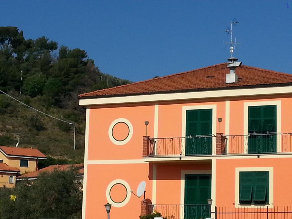ein orangefarbenes Gebäude mit Balkon darüber in der Unterkunft Albergo Jolanda in Diano Marina