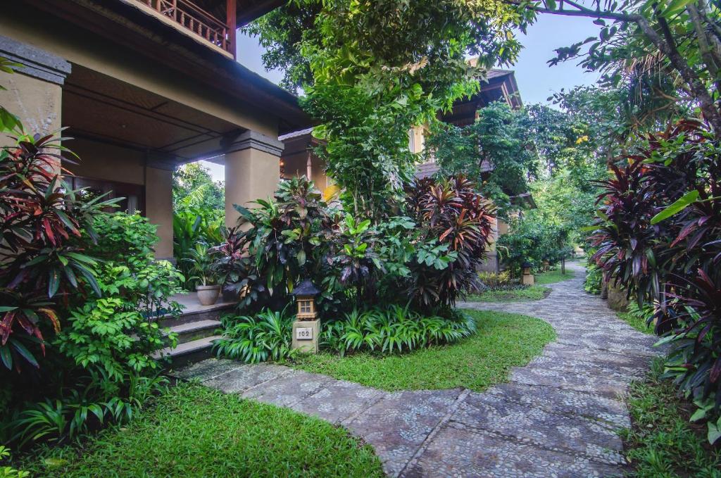 a walkway in front of a house with plants at Sri Phala Resort & Villa in Sanur
