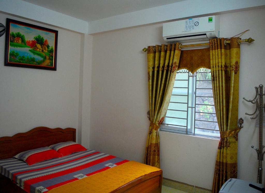 um quarto com uma cama e uma janela em Huong Thao 2 Hotel em Ha Giang
