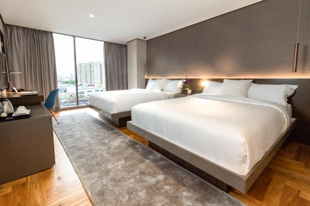 Postel nebo postele na pokoji v ubytování Ramada Encore by Wyndham Makati