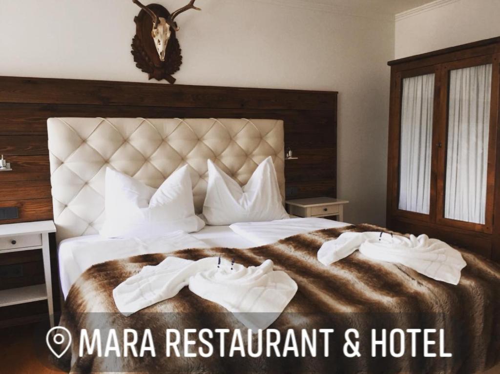 En eller flere senge i et værelse på Mara Restaurant & Hotel