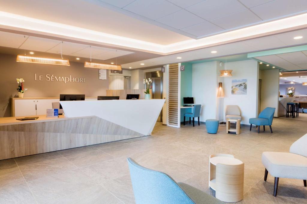 a waiting area in a dermatologists office with chairs and tables at Best Western le Sémaphore in Rang-du-Fliers