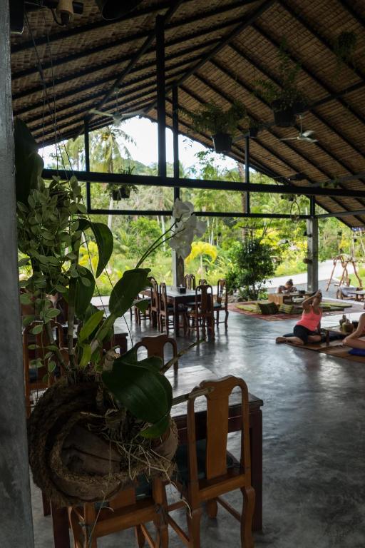 a room with chairs and a table and a plant at Wonderland Healing Center in Thongsala