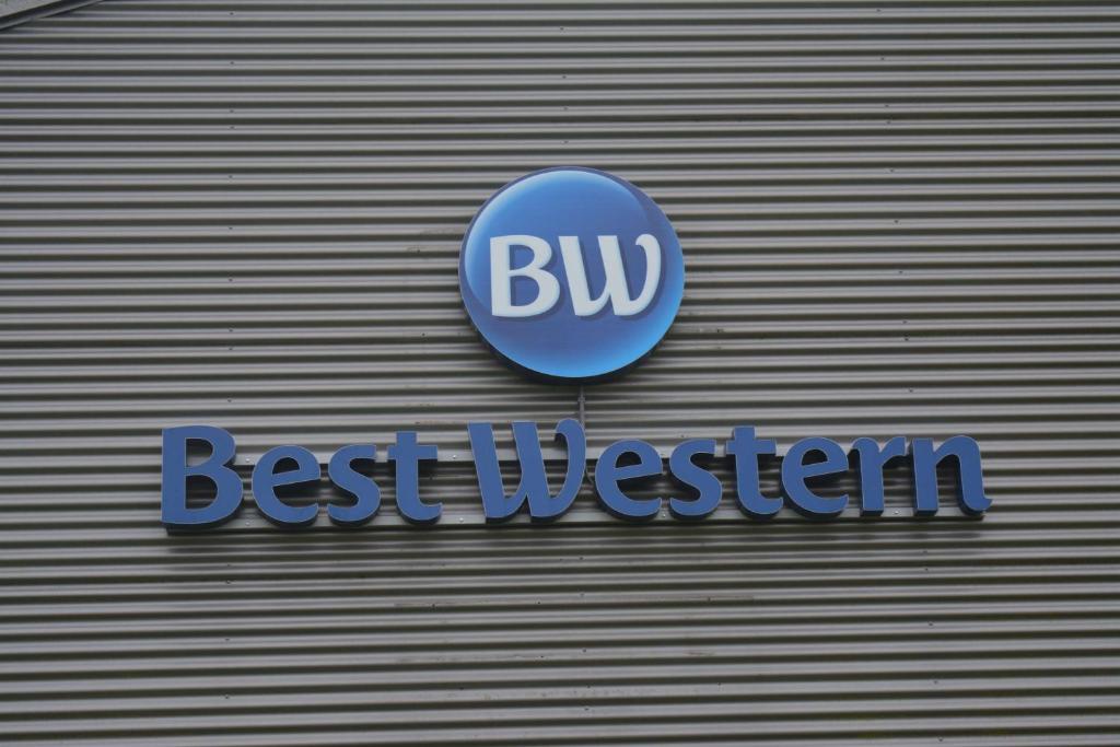 een blauw bord aan de zijkant van een gebouw bij BEST WESTERN Hotel Brussels South in Ruisbroek