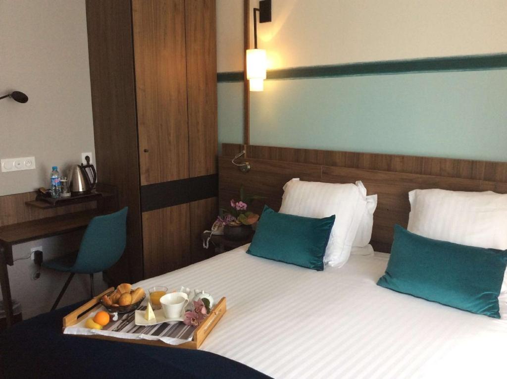 una stanza d'albergo con un letto con un vassoio di cibo sopra di Best Western Le Duguesclin Hôtel-Restaurant a Saint-Brieuc