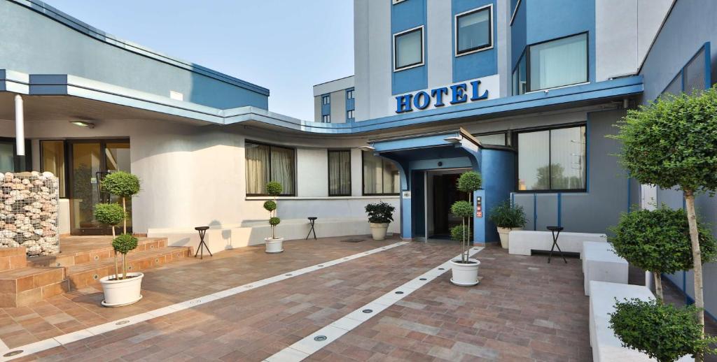 un hôtel doté d'une cour avec des plantes en pot en face de lui dans l'établissement Best Western Plus Soave Hotel, à San Bonifacio
