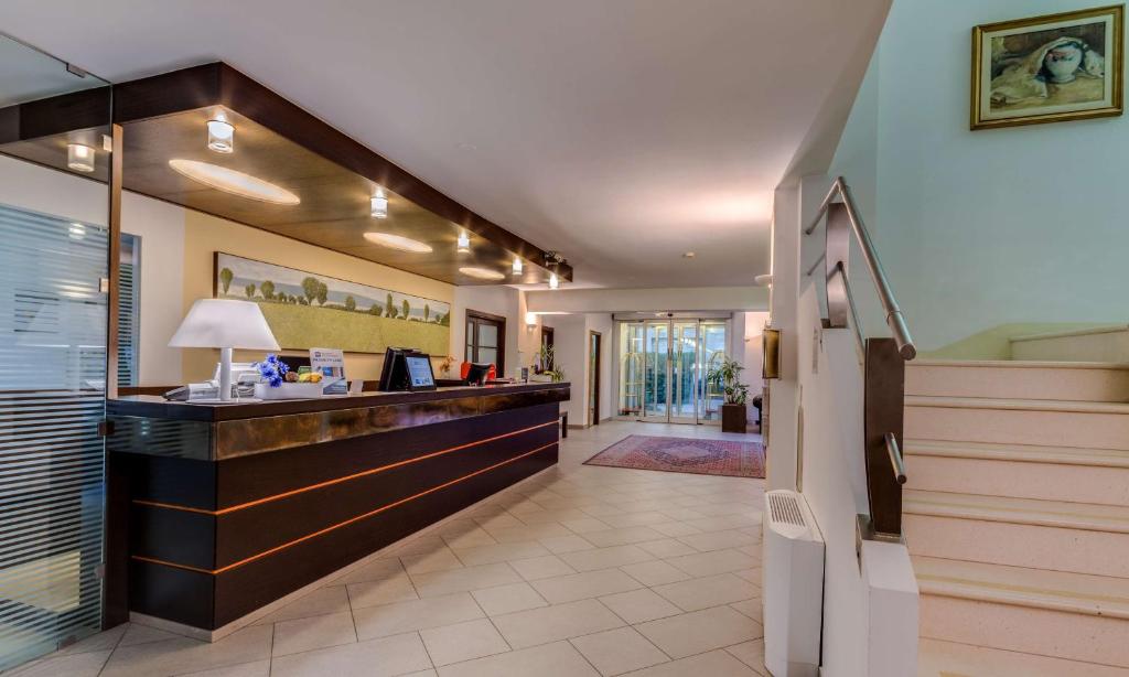 a hotel lobby with a reception desk and stairs at Best Western City Hotel in Bologna