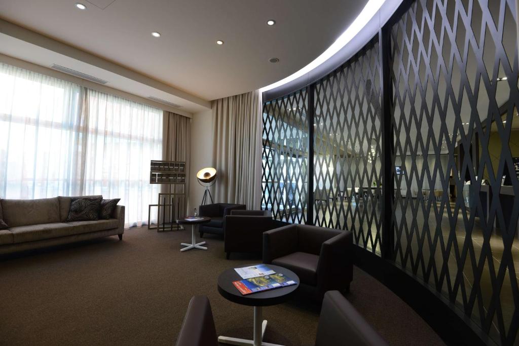 a living room with a couch and a table at Best Western Premier CHC Airport in Genoa