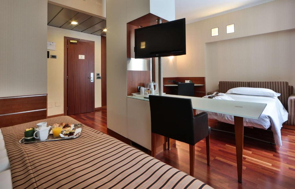 a hotel room with a bed and a table with a plate of food at Best Western Madison Hotel in Milan