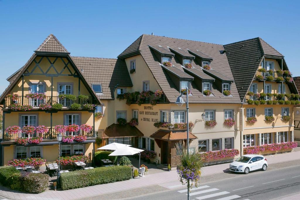 un gran edificio con macetas en los balcones en Best Western Plus Au cheval Blanc à Mulhouse, en Baldersheim