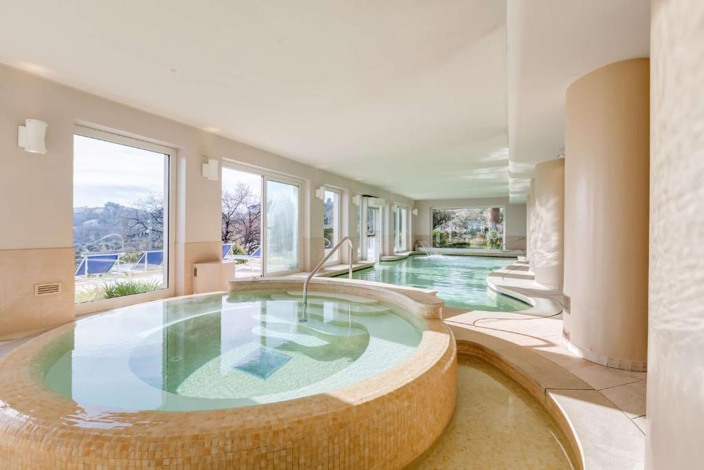 an indoor swimming pool with a large circular tub at Villa Maria Hotel & SPA in Francavilla al Mare
