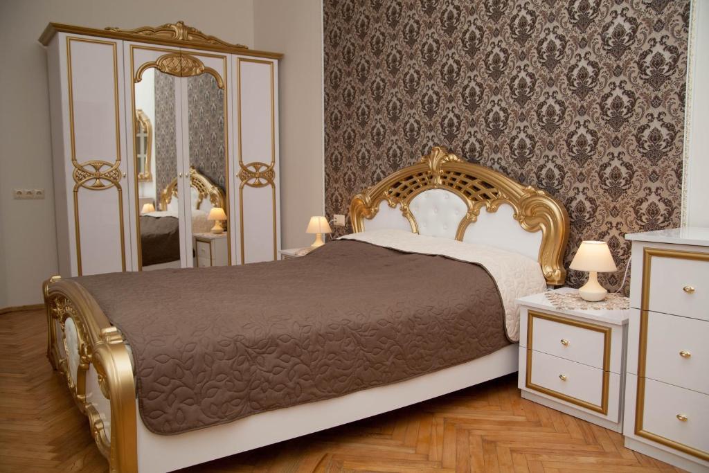 リヴィウにあるLuxury Lviv Apartmentのベッドルーム(金製ベッド1台、鏡付)
