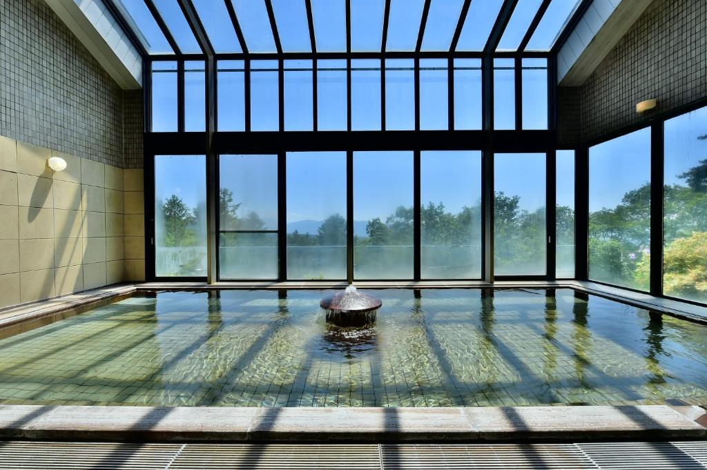Habitación grande con piscina y ventanas. en Tateshina Park Hotel, en Chino