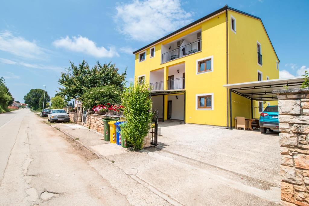 un edificio amarillo al lado de una calle en Nice place en Rovinj