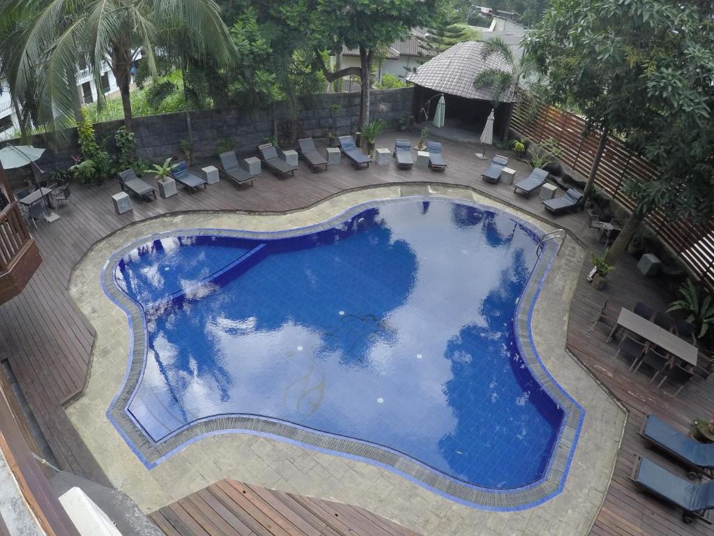 an overhead view of a large swimming pool with chairs and a deck at Hotel Sunray in Kandy