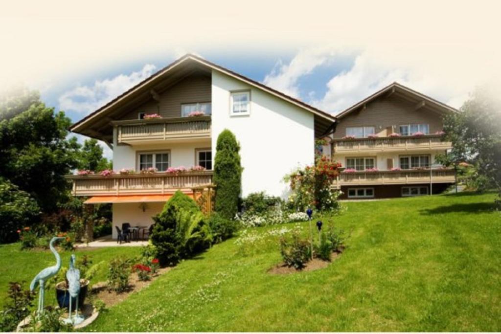 a large house with a green lawn in front of it at Pension Landhaus Hochfeld in Zwiesel
