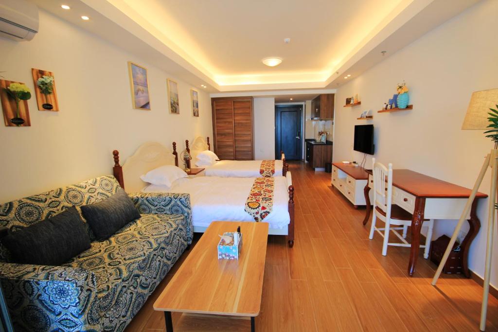 a hotel room with a bed and a couch and a table at Coast-Inn Hailing Island in Yangjiang