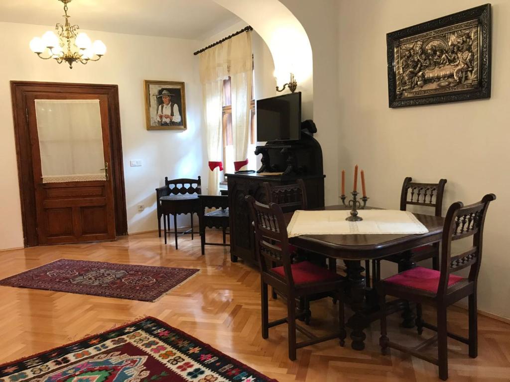 ein Esszimmer mit einem Tisch, Stühlen und einem TV in der Unterkunft Casa Livia Brasov in Braşov