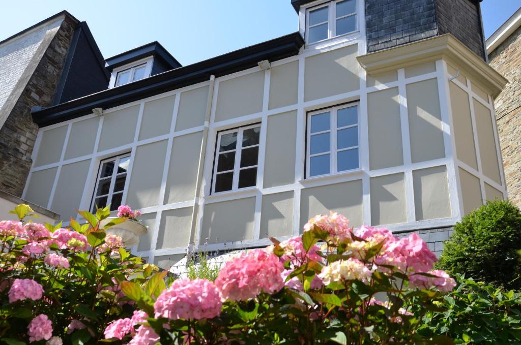 una casa con flores rosas delante de ella en Le Petit Maur, en Spa