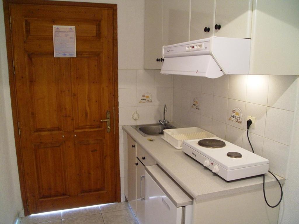 a kitchen with a counter with a sink and a door at Villa Maro in Skopelos Town