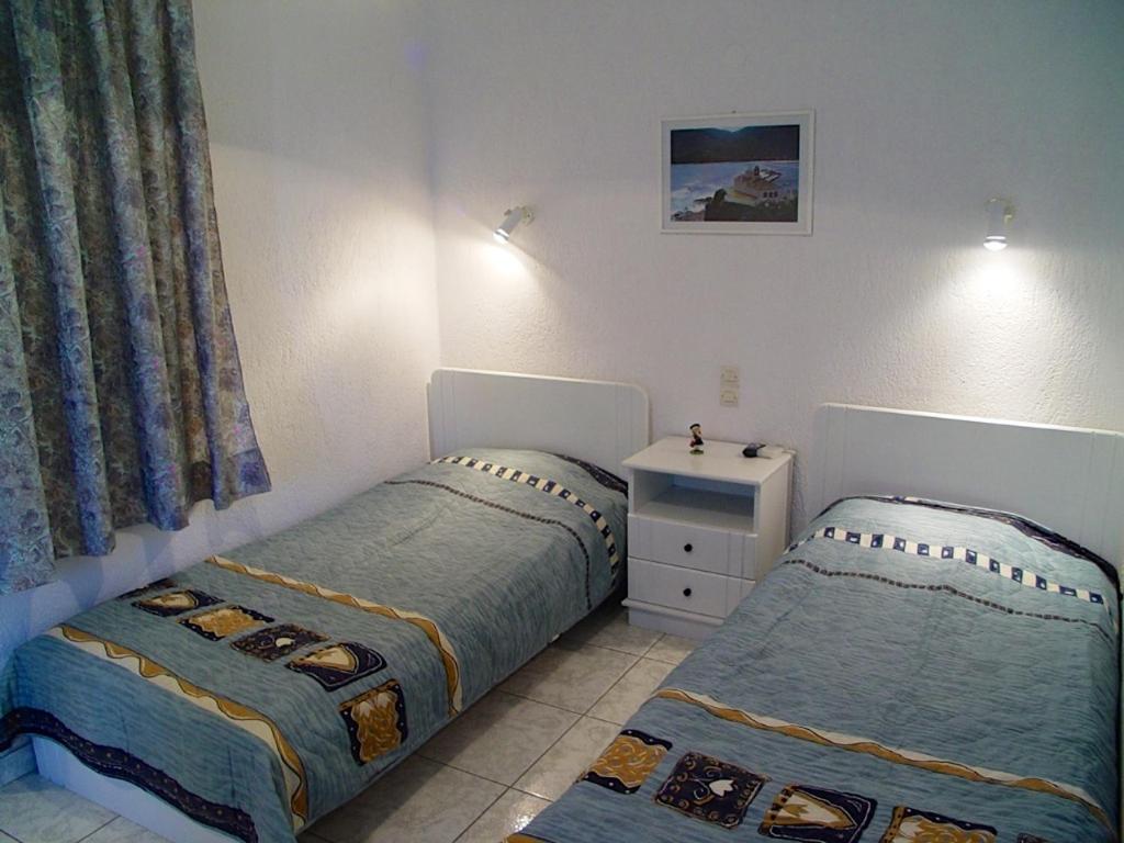 a bedroom with two beds and a dresser at Villa Maro in Skopelos Town