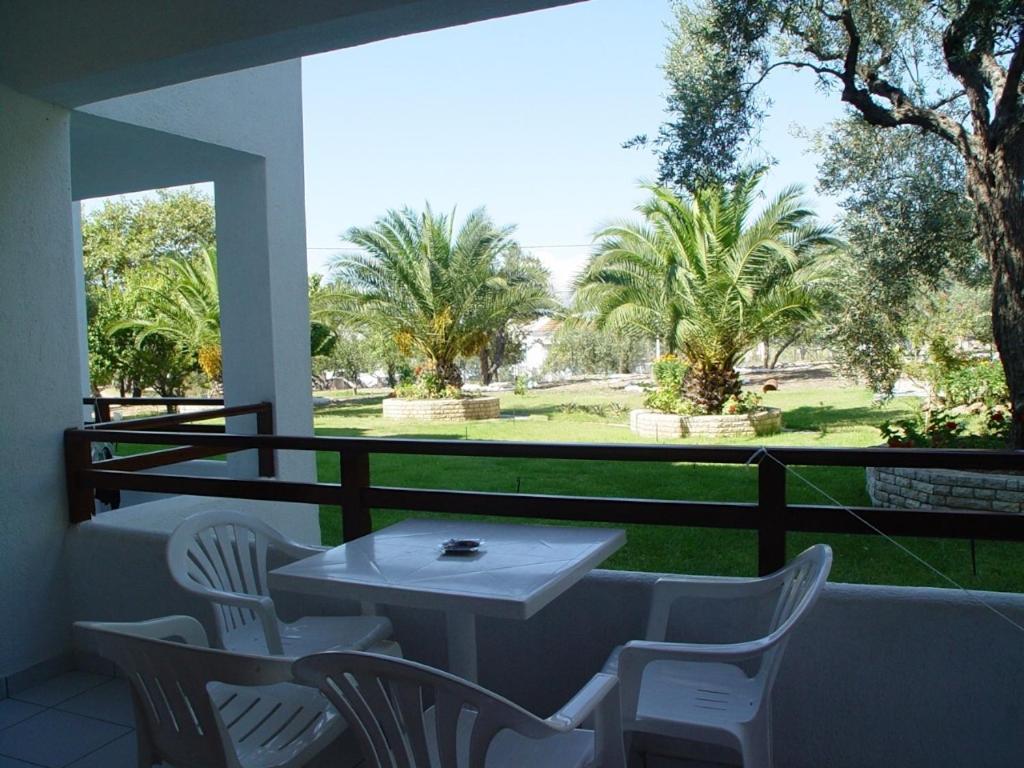 a white table and chairs on a balcony with trees at Villa Maro in Skopelos Town