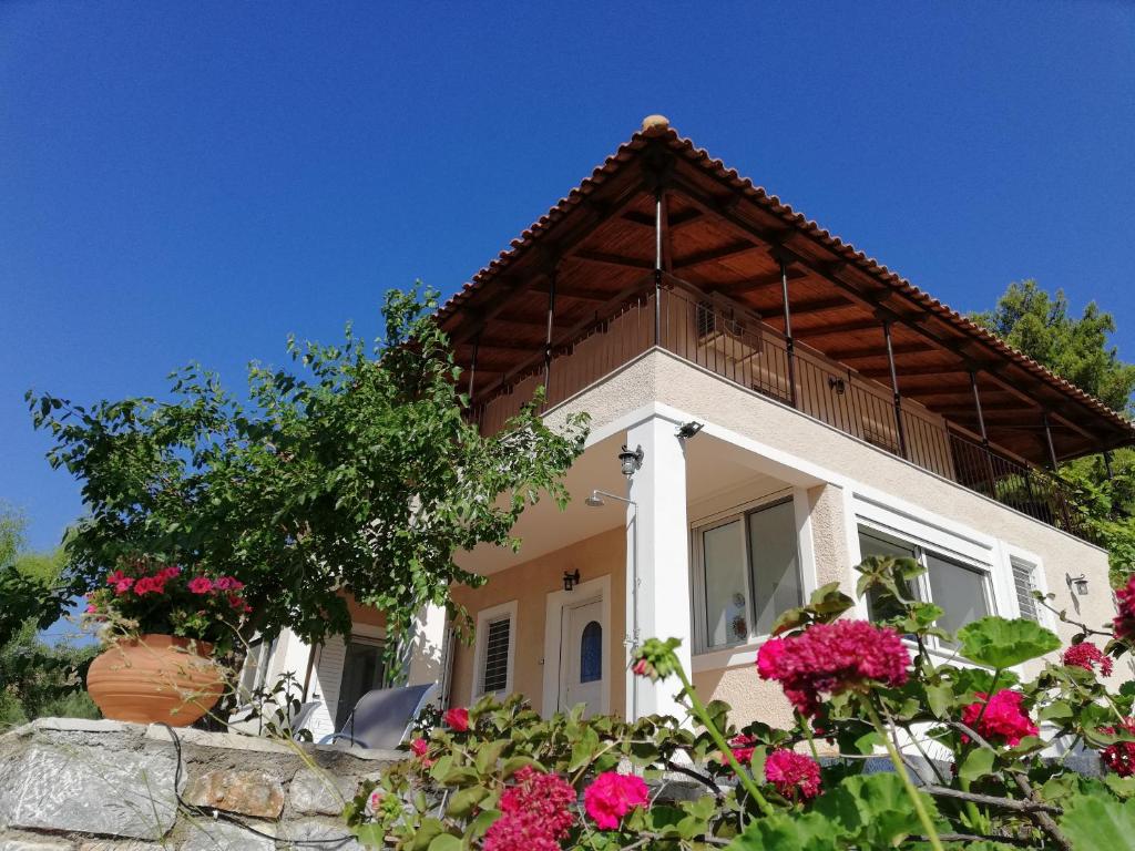 a house with flowers in front of it at Olea Escape Villa in an Olive Estate in Gythio