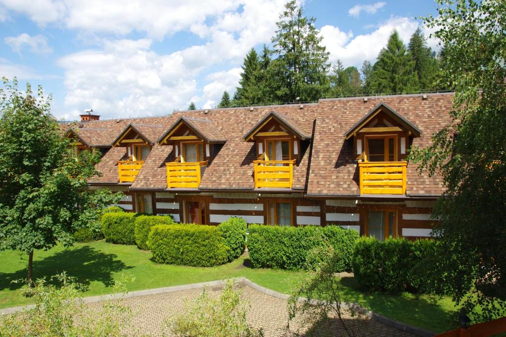 una grande casa con finestre gialle e cespugli di Kamratowo a Wisła