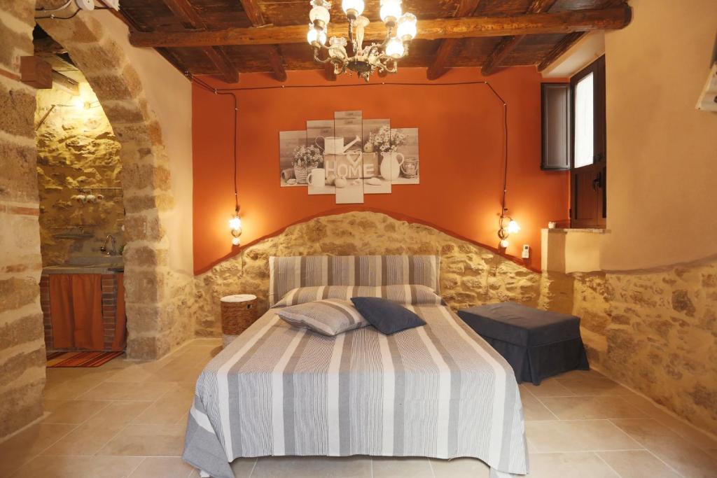 ein Schlafzimmer mit einem Bett mit einer orangefarbenen Wand in der Unterkunft Il palazzetto del pescatore in Augusta
