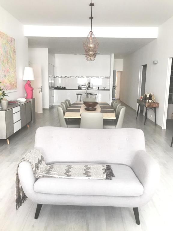 sala de estar con sofá blanco y mesa en Les lofts de Styliste, en Bruselas