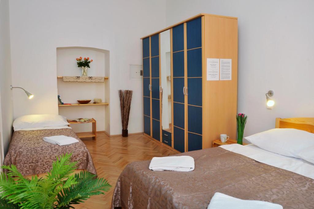 a hotel room with two beds and a cabinet at Pension Prague City in Prague