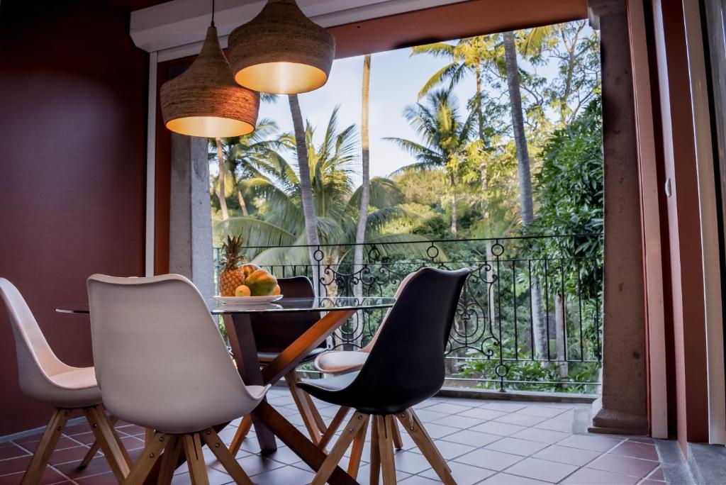 a dining room with a table and chairs and a balcony at Villa 202 in Port Louis