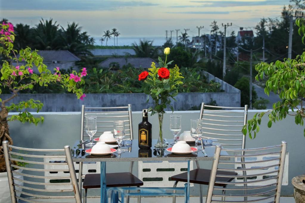 una mesa con una botella de vino y flores. en Hoi An Sea Sunset Homestay and Bar, en Hoi An