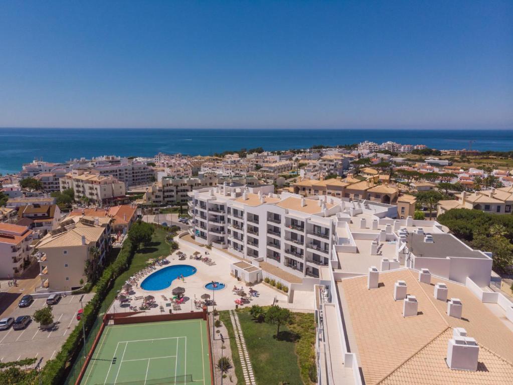 eine Luftansicht eines Resorts mit Tennisplatz in der Unterkunft Vista das Ondas - AP in Albufeira