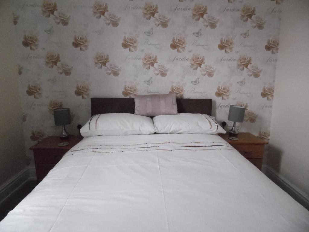 1 dormitorio con 1 cama con 2 mesitas de noche y 2 lámparas en Maryland Bed and Breakfast, en Bridlington