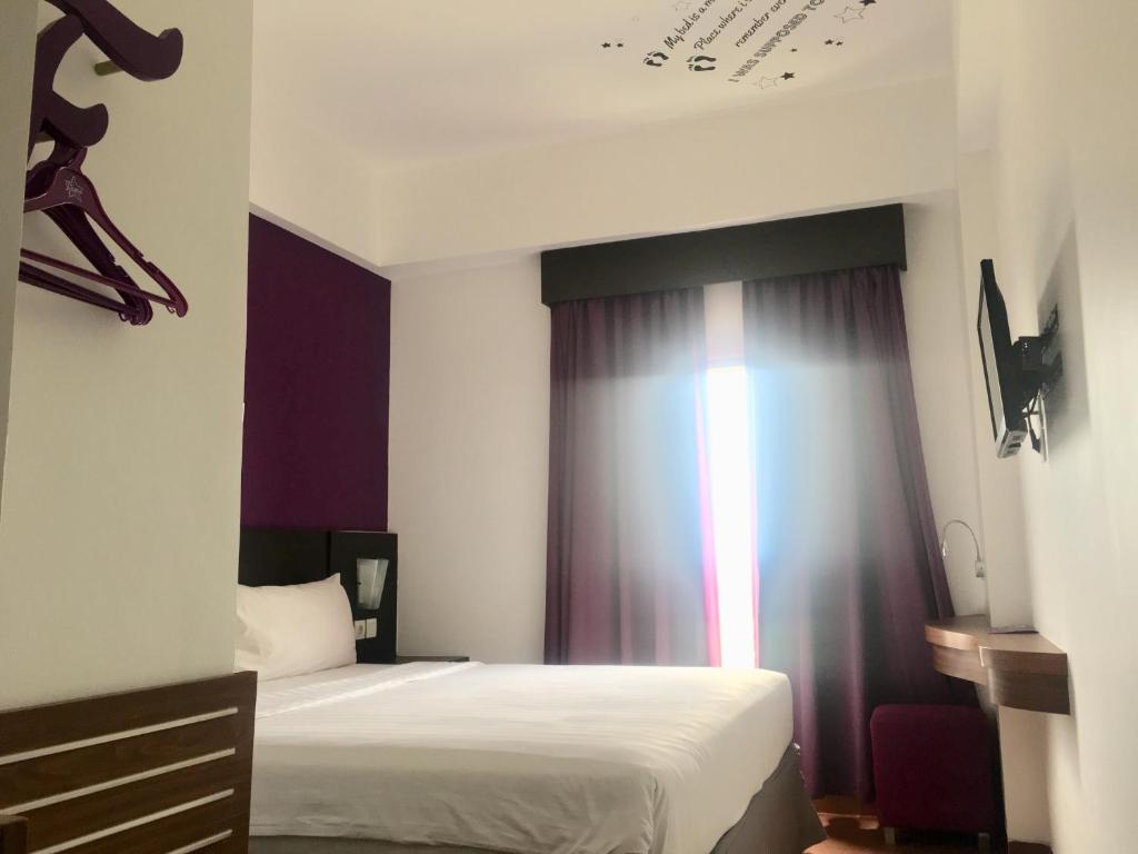 Postel nebo postele na pokoji v ubytování Fame Hotel Gading Serpong