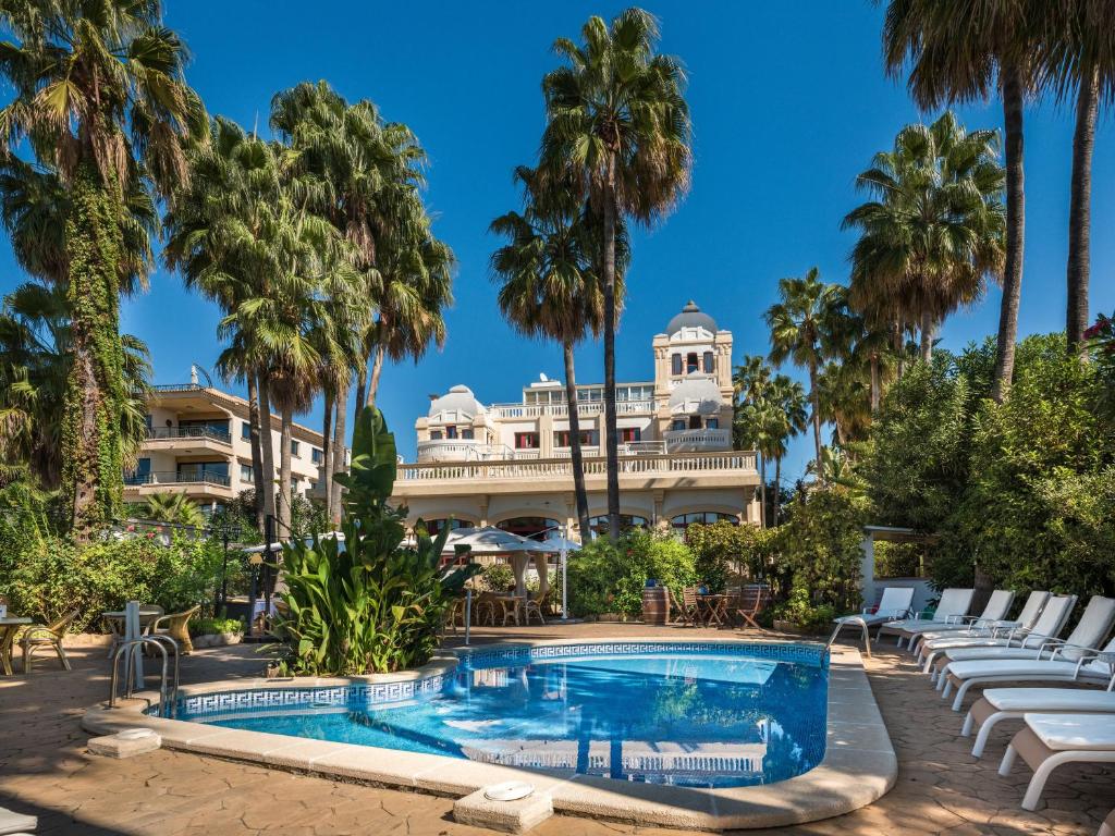Hotel Ciutat Jardi في بالما دي ميورقة: منتجع فيه مسبح والنخيل