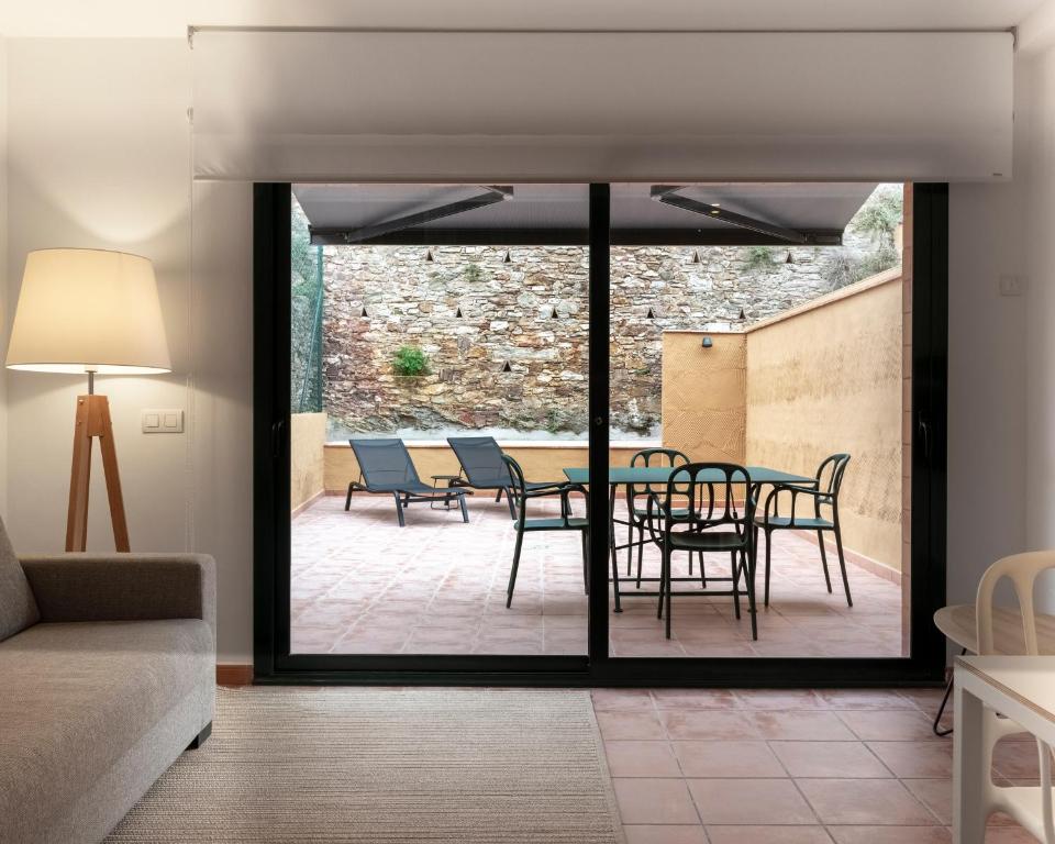 een woonkamer met een tafel en stoelen op een patio bij Alta House Apartments 4 Vents in Begur